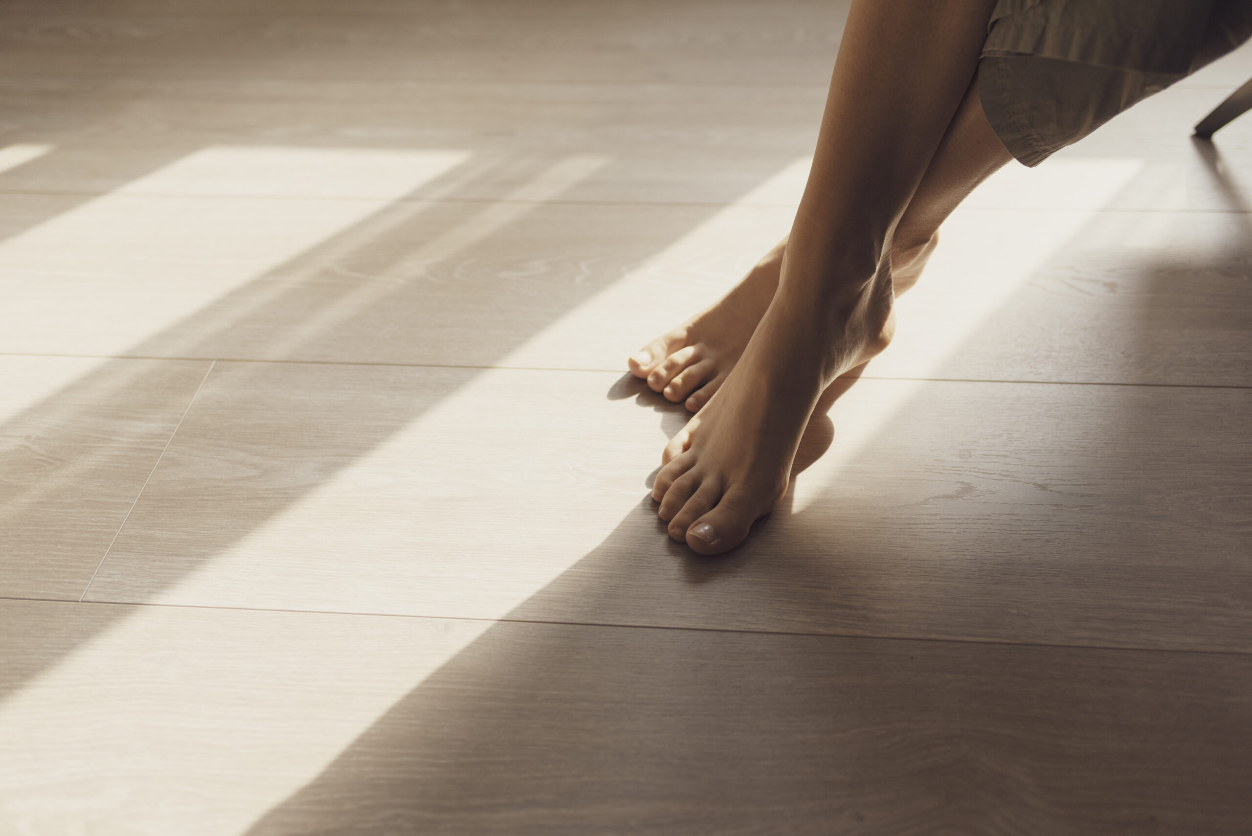 Bare feet resting on a sunlit warm floor