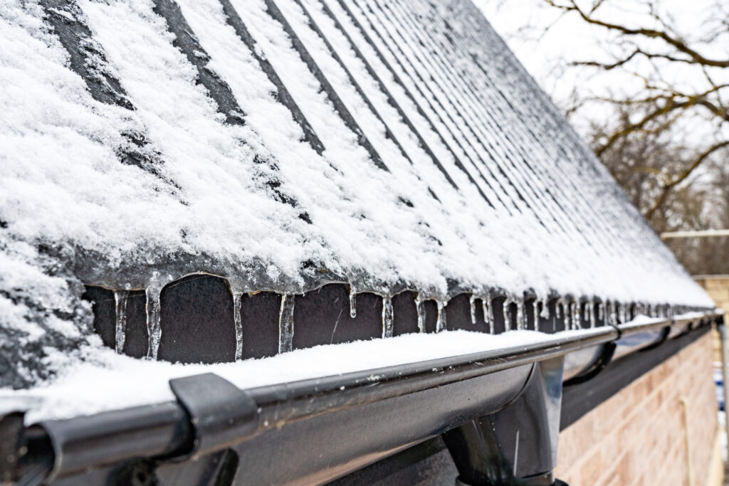 Snow and icicles along a roof edge and gutter